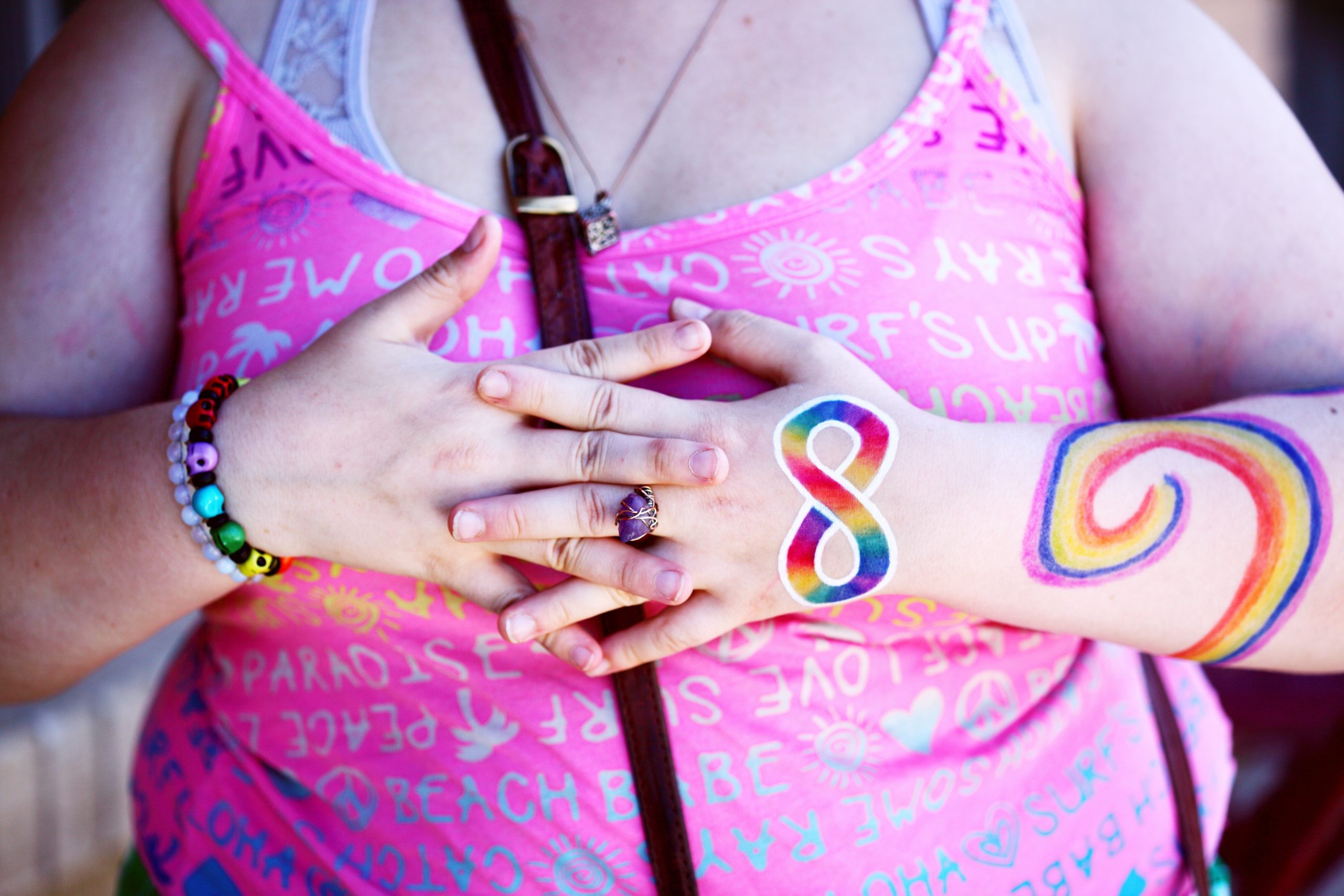 Image of a person wearing the autism pride symbol - a rainbow infinity symbol